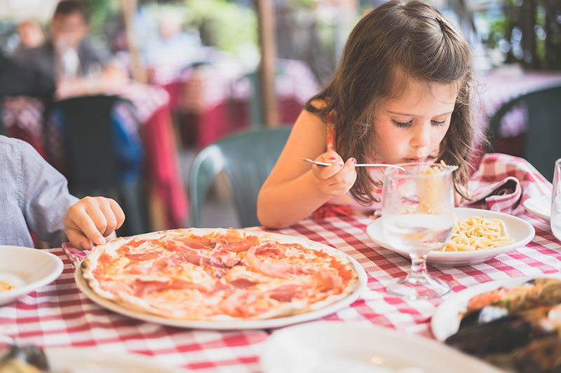 малко момиче се храни със спагети и пица