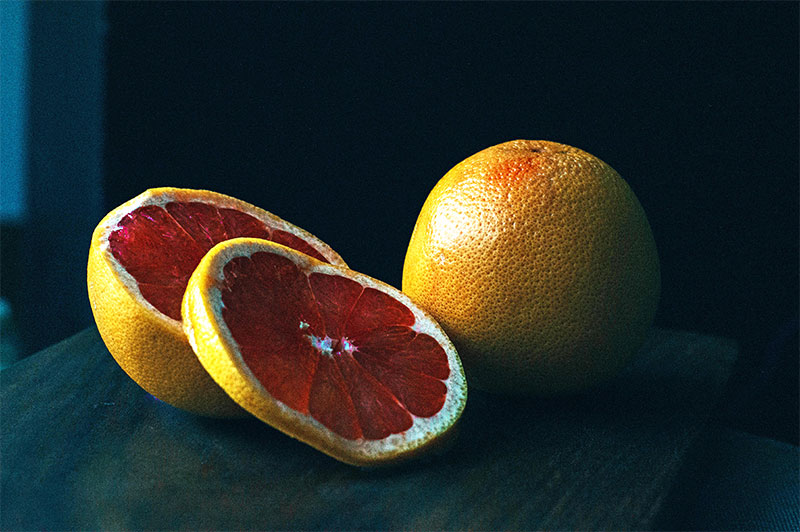 цял и нарязан грейпфрут на черен фон