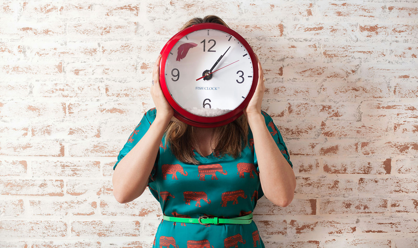 жена държи часовник пред лицето си в очакване да се нахрани