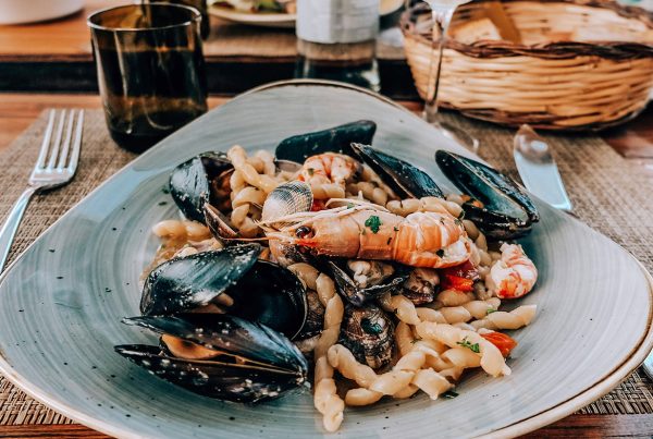 чиния със средиземноморска храна и скарида на преден план