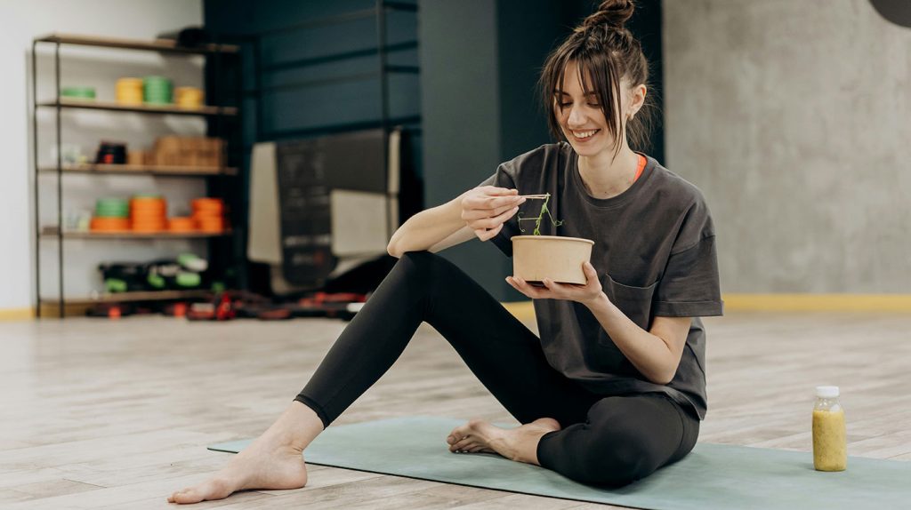 млада жена се хране след тренировка в залата