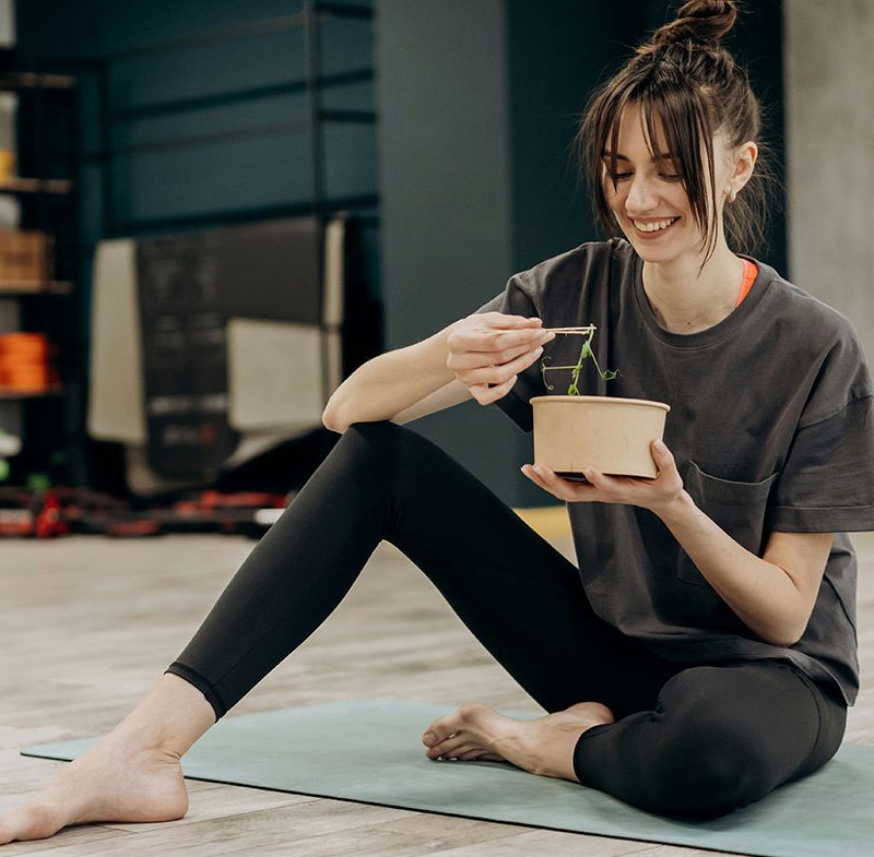 млада жена се хране след тренировка в залата